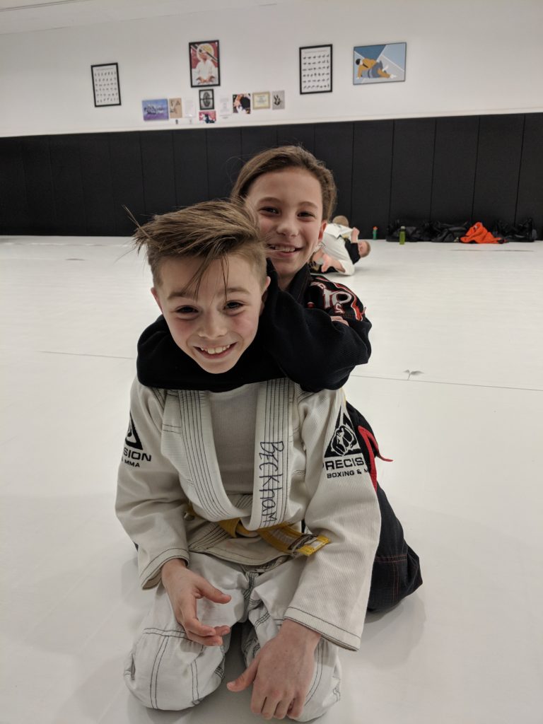 Two Young Students learning BJJ and smiling at camera